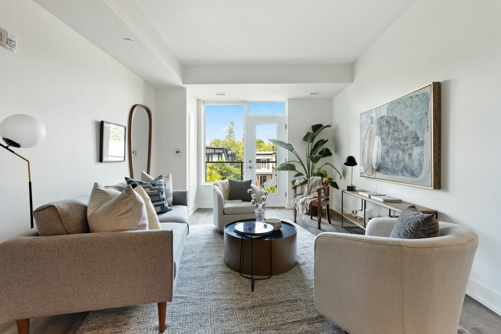 Bright living room with white sofas and large window