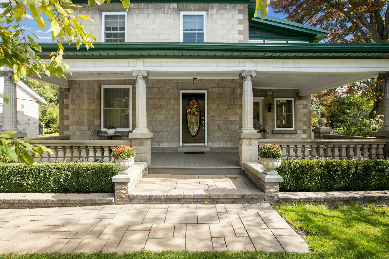 Stone home with green roof and front porch