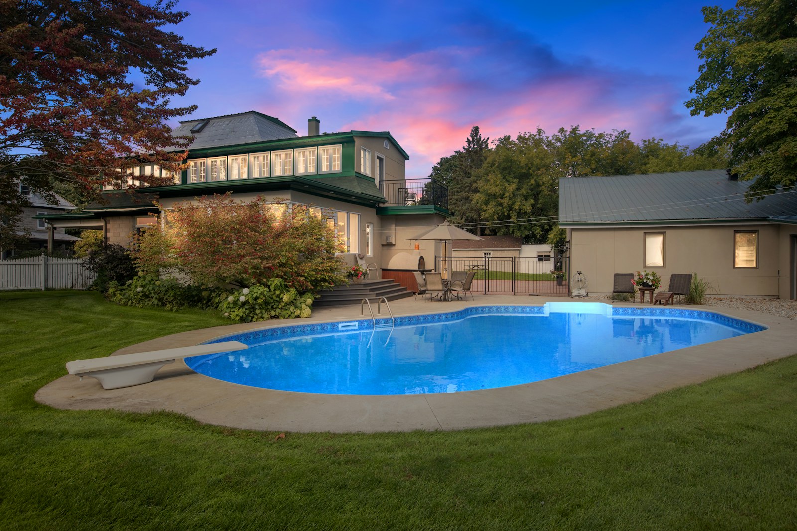 Pool and home exterior at twilight