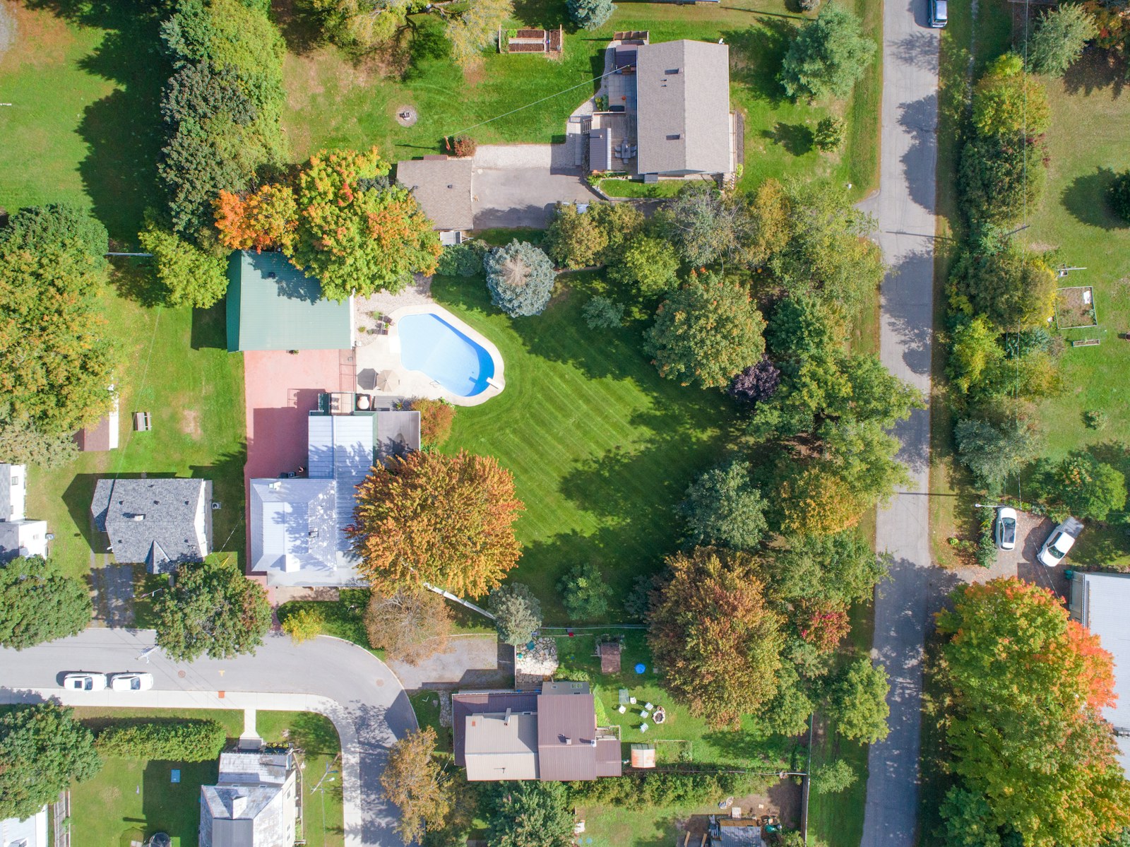 Top-down aerial view of a house, yard, and pool