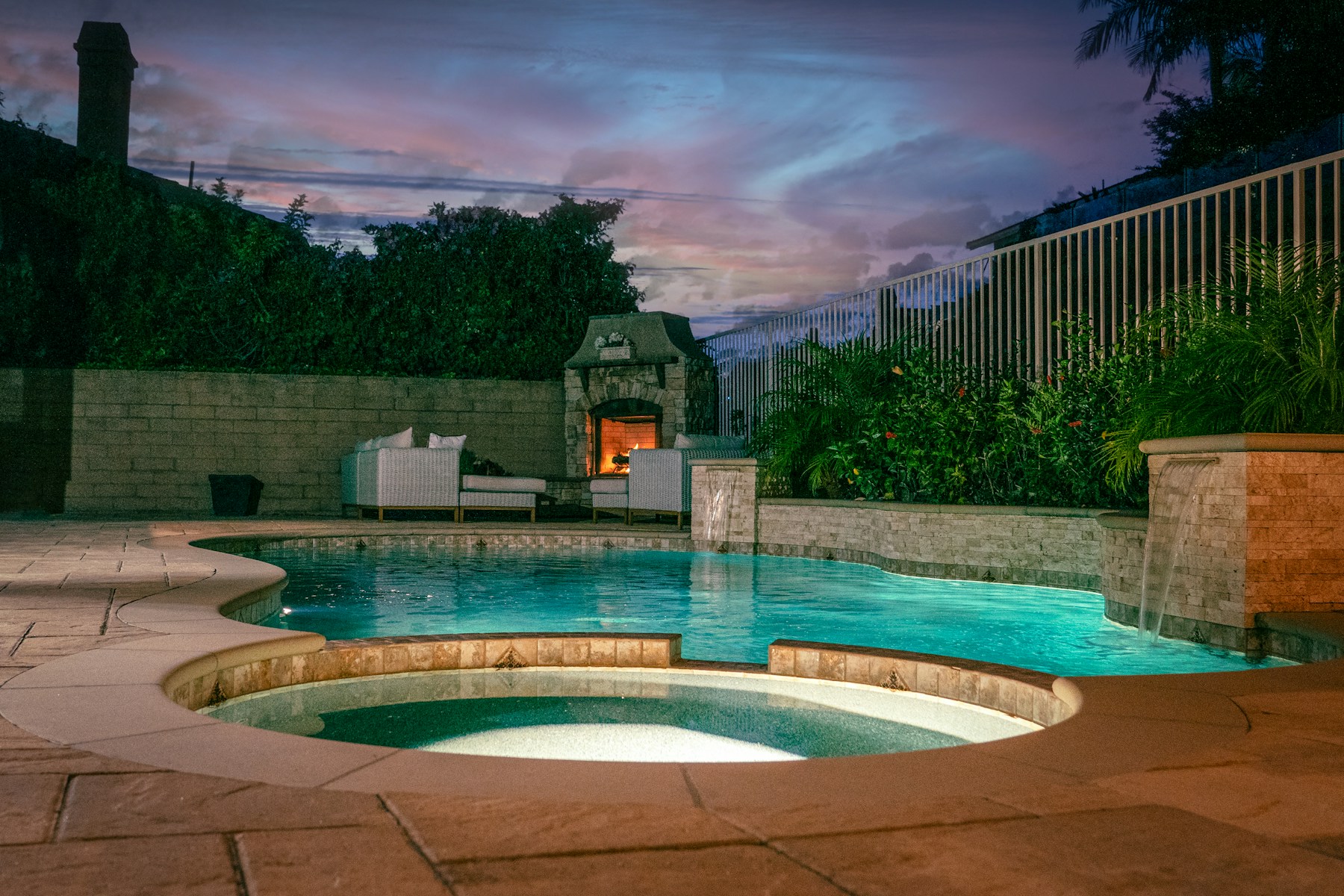 Pool and spa with outdoor seating at sunset